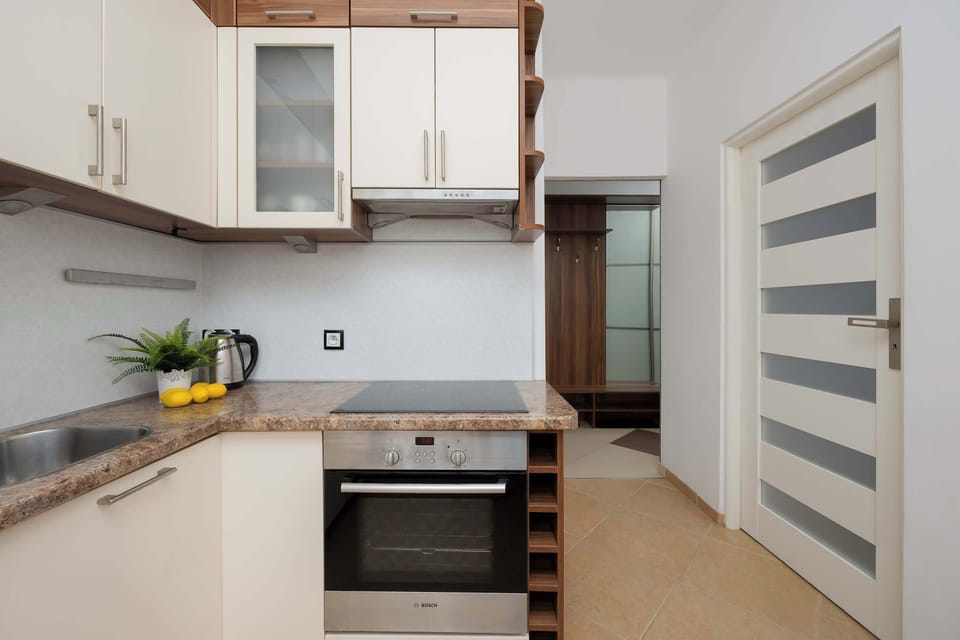 A kitchen angle showing the oven and storage cabinets. Clean lines and neutral colors dominate the space. The room feels modern and functional.