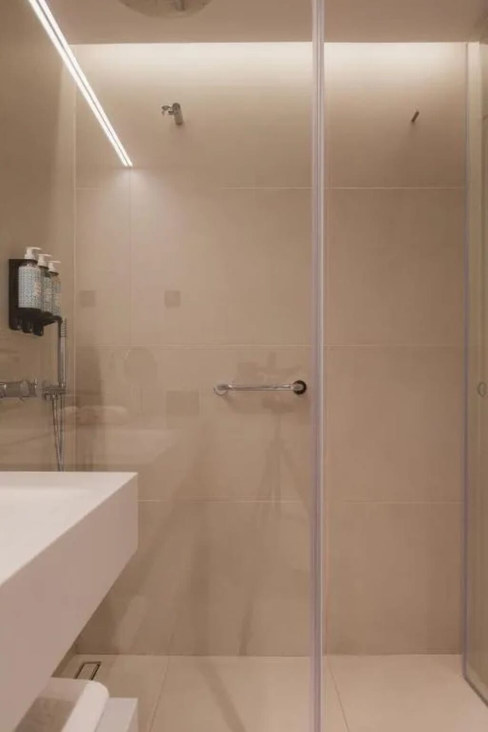 Rinse off under a spacious glass shower with premium dispensers.