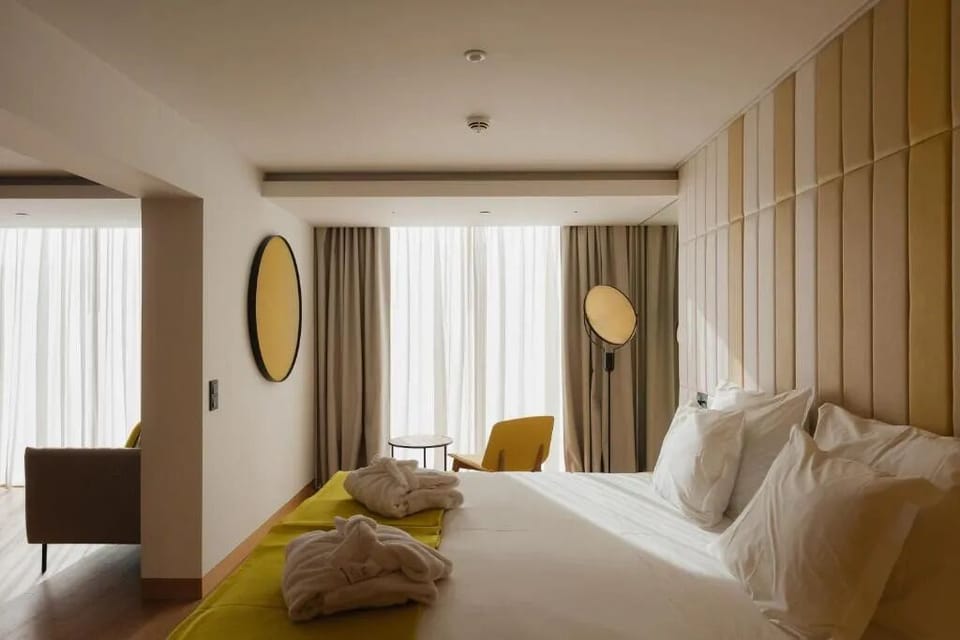 Unwind in crisp linens with sunlit, floor-to-ceiling curtains.
