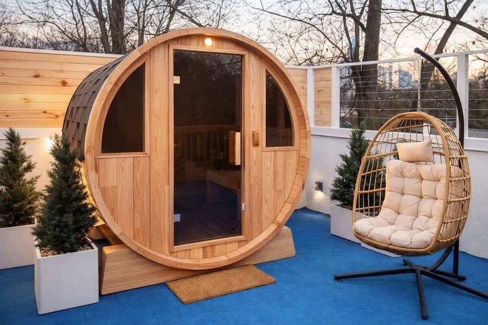 Private rooftop barrel sauna surrounded by greenery with a cozy hanging chair nearby. A peaceful wellness retreat designed for relaxing, recharging, and unwinding above the city at Teeni Santorini.