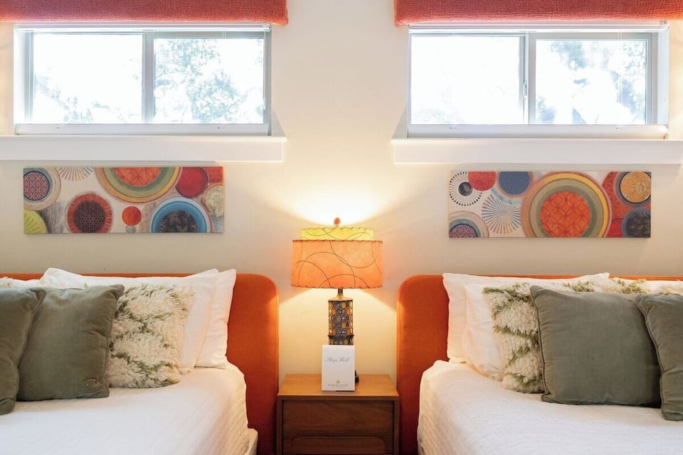 Unwind in your bright, art-filled bedroom with queen beds and vibrant decor.