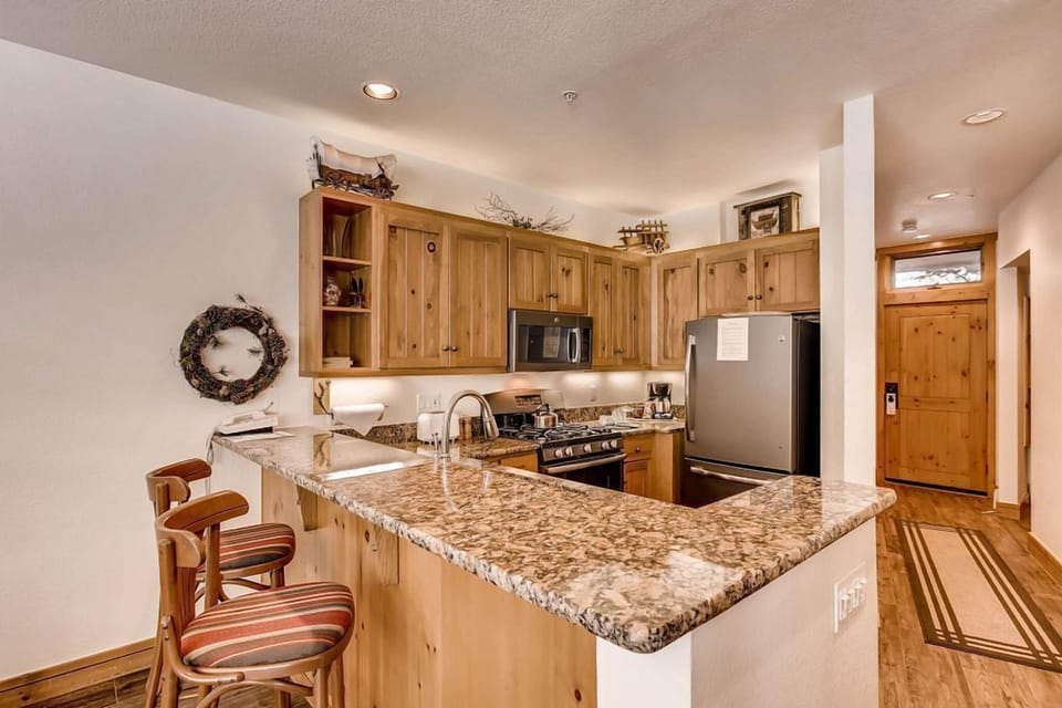 This well-appointed kitchen features warm wooden cabinetry and sleek granite countertops, making meal prep a delight whether you're cooking a family dinner or enjoying a casual breakfast.