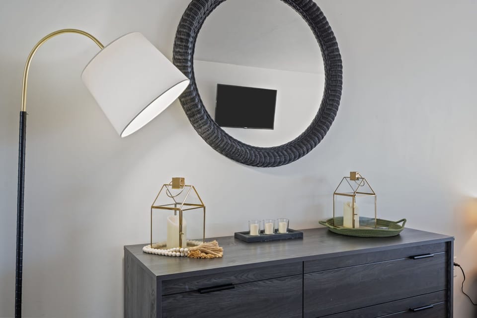 Thoughtfully styled dresser with soft lighting, mirror, and coastal-inspired accents