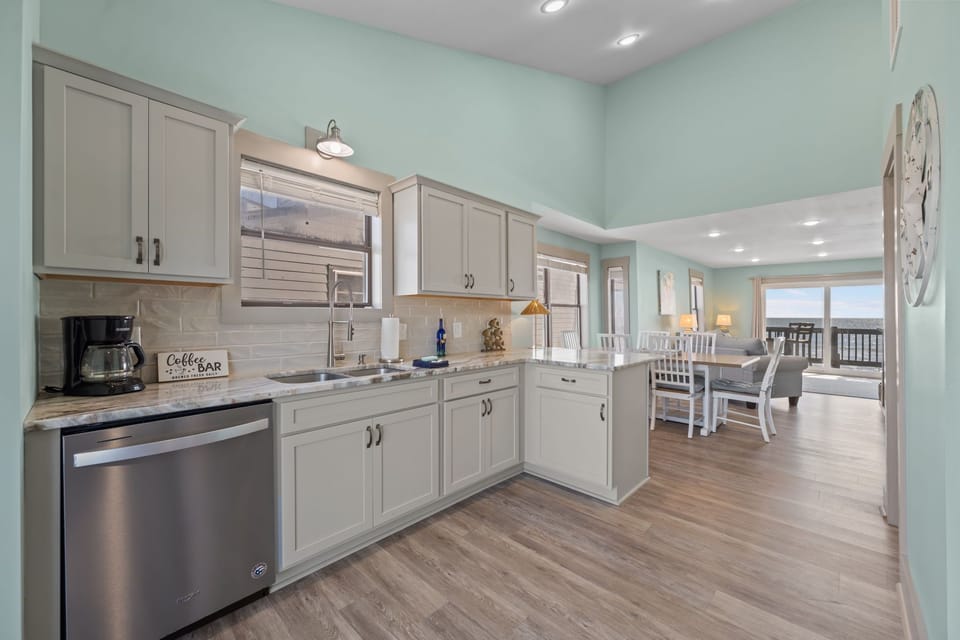 Coastal-style kitchen with modern appliances, ample counter space, and a seamless flow into the dining and living areas, plus beautiful ocean views just beyond