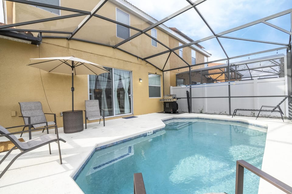 Private screened pool patio with cozy seating and sunshade
