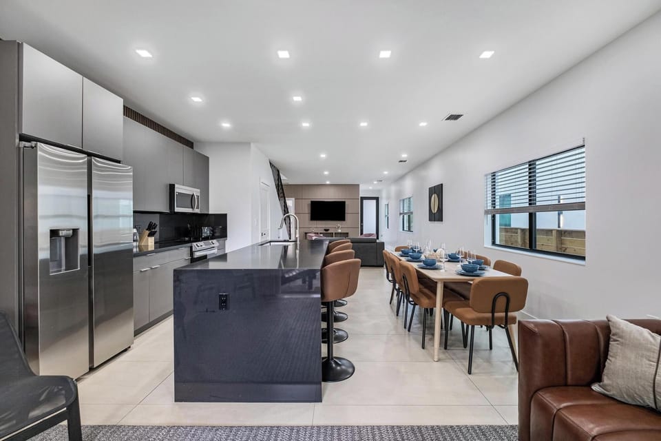 Modern open kitchen and dining area with a large island and seating for eight.