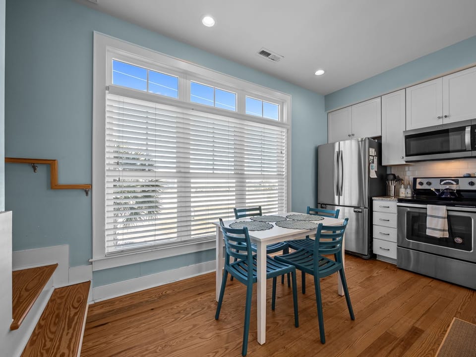 Bright eat-in kitchen with large windows and modern appliances 