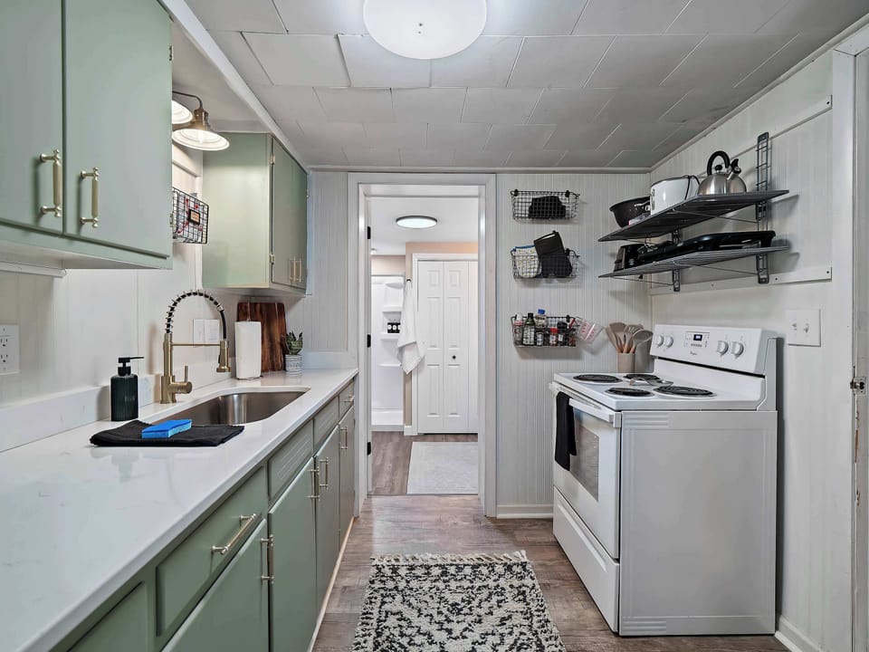Narrow galley kitchen w/ ample cabinets, window light & all essentials within easy reach