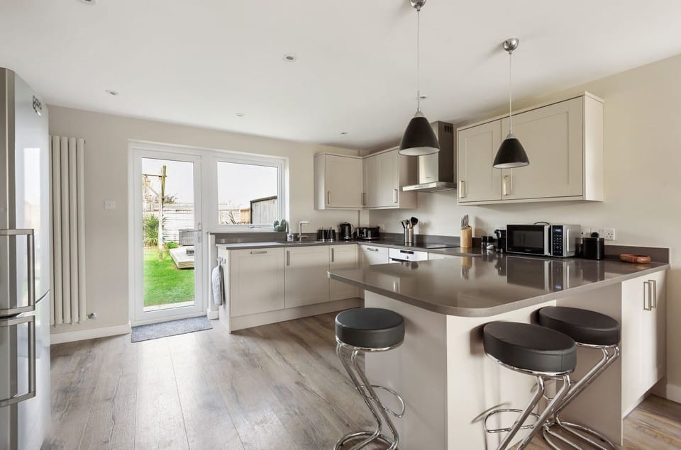 Contemporary, well-equipped fitted kitchen with breakfast bar