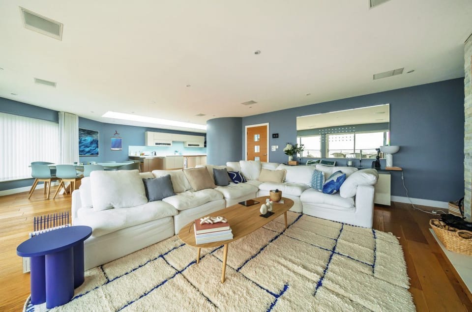 Huge corner sofa gazing out to sea with the bi-folds wide open.