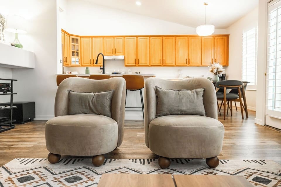 Relaxing seating area with plush accent chairs and open view to the kitchen and dining space.