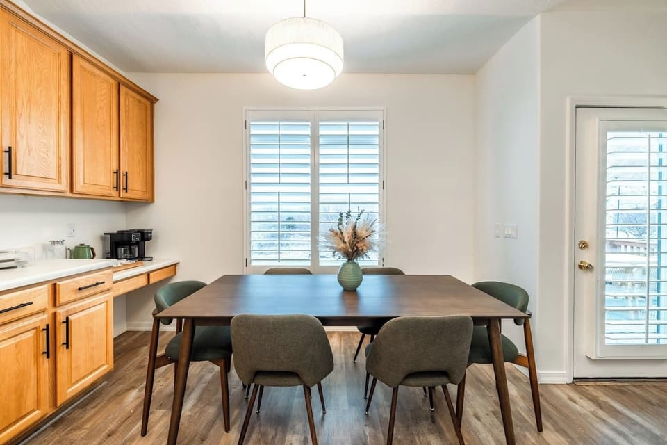 Comfortable dining space with table seating, ample light, and direct kitchen access.