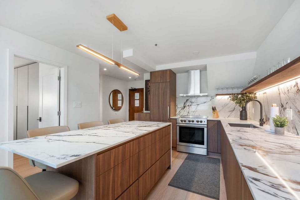Connect over food in this open space living plan. Featuring island stools.
