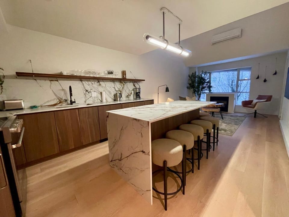 Connect over food in this open space living plan. Featuring island stools.