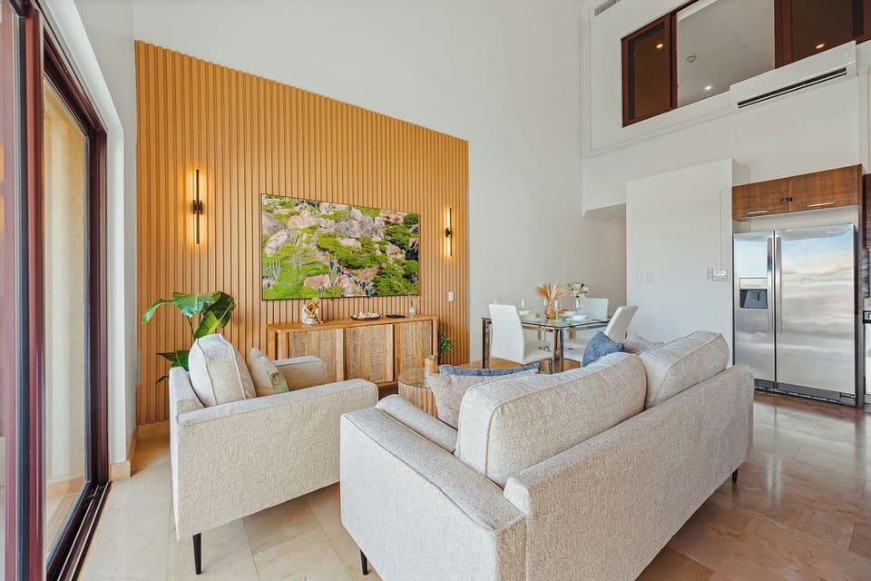 Kick back in this stylish living space featuring a large TV, contemporary décor, and plenty of natural light. A perfect spot to relax, stream, and recharge.