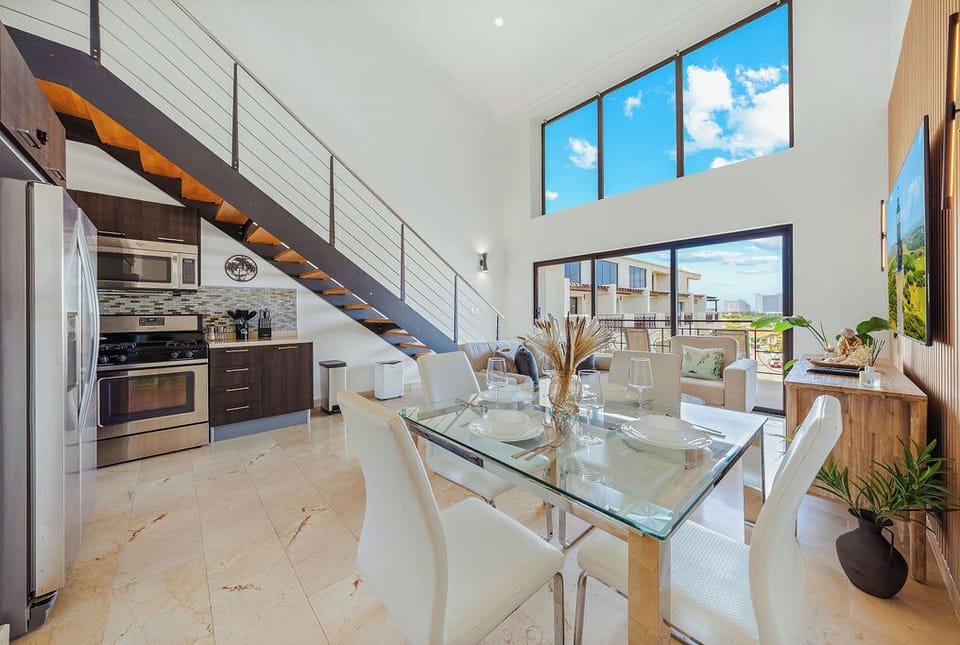 Gather and dine in a light-filled space with a modern glass table and balcony views—perfect for shared meals and relaxed evenings.