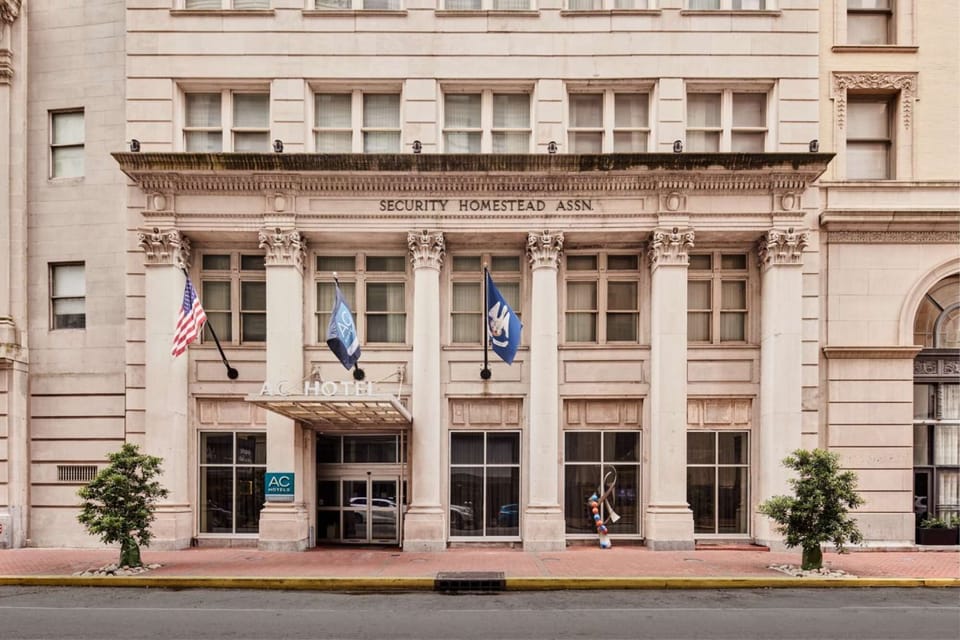 Property entrance with flags, tall columns, and glass doors
