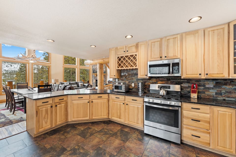 Your gourmet kitchen awaits with granite counters, stainless appliances, and stunning mountain views through expansive windows.
