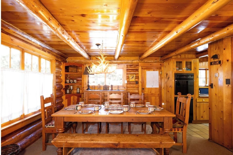 Gather around this beautiful log dining table where sunlight streams through and your group can share memorable meals together in warm, rustic comfort.