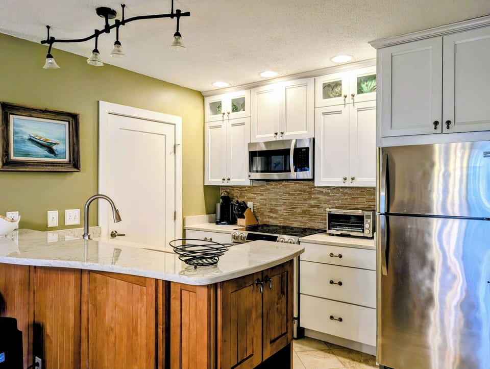 15002 Tall Pines Ct - Gourmet Kitchen - Prepare beach snacks or full meals in this updated kitchen featuring sleek stainless steel appliances and crisp white cabinetry. The breakfast bar offers additional seating and a great social hub for the chef in the family.