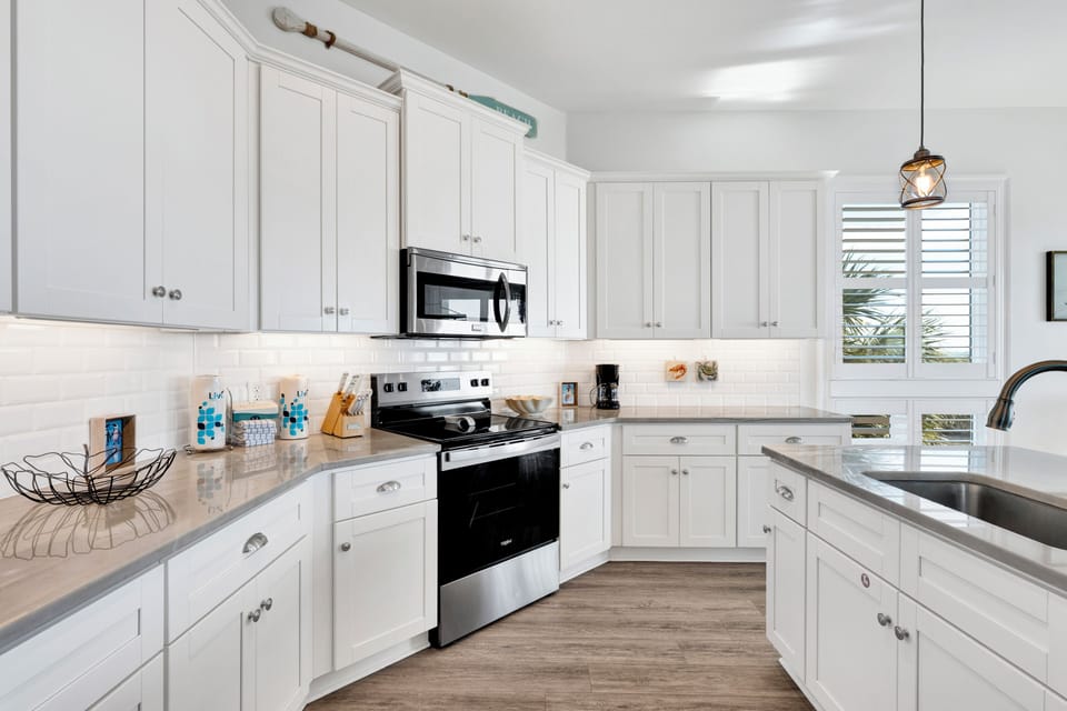 Your bright, modern kitchen features gleaming white cabinets, stainless steel appliances, and granite countertops—perfect for cooking memorable vacation meals.
