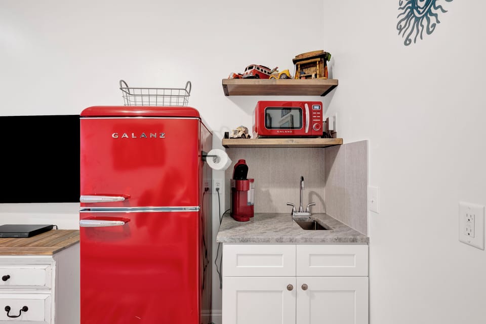 The 2nd living area has an arcade machine, TV and kitchenette with mini fridge and sink