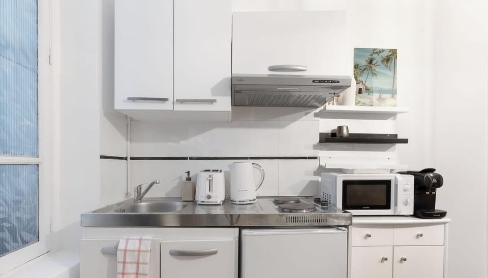 Kitchenette fonctionnelle, équipée pour tous les besoins quotidiens (micro-ondes, plaque, réfrigérateur, machine à café).