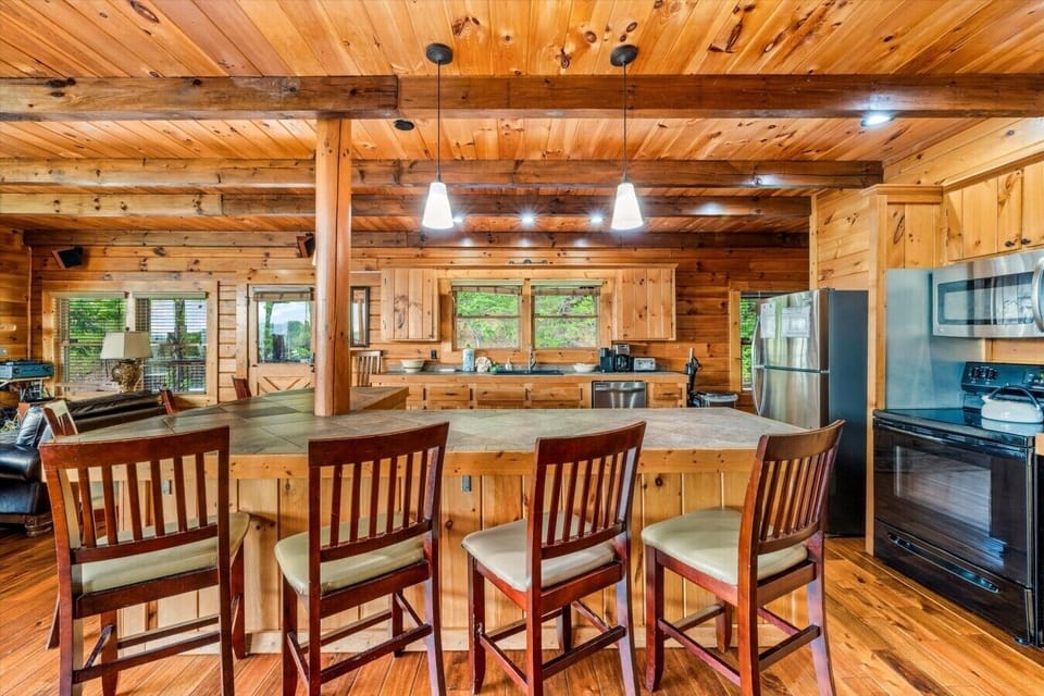 A large wraparound breakfast bar provides extra seating, making it the perfect gathering place for morning coffee, snacks, or conversation while meals are prepared.