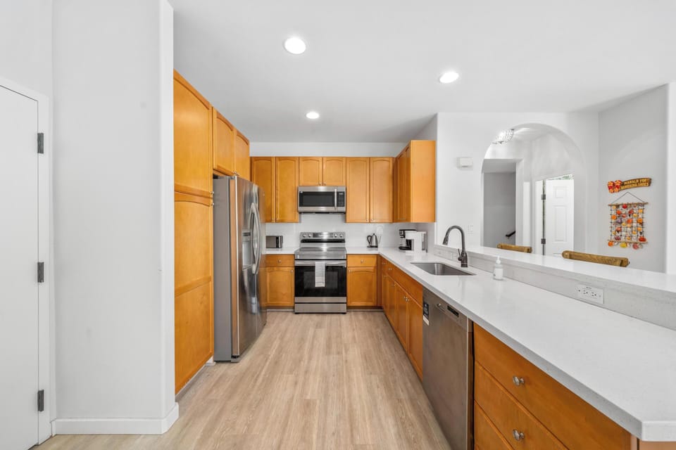 Your fully equipped kitchen awaits with warm wood cabinets, stainless steel appliances, and plenty of space to create memorable meals together.