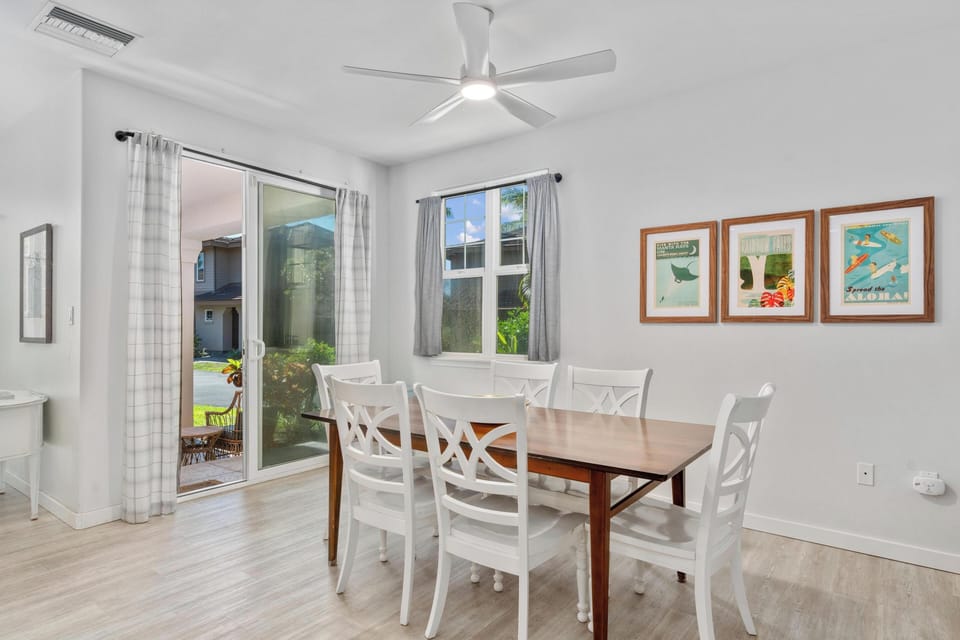 Your bright dining space features a welcoming table for six, ceiling fan for comfort, and garden access through sliding doors.
