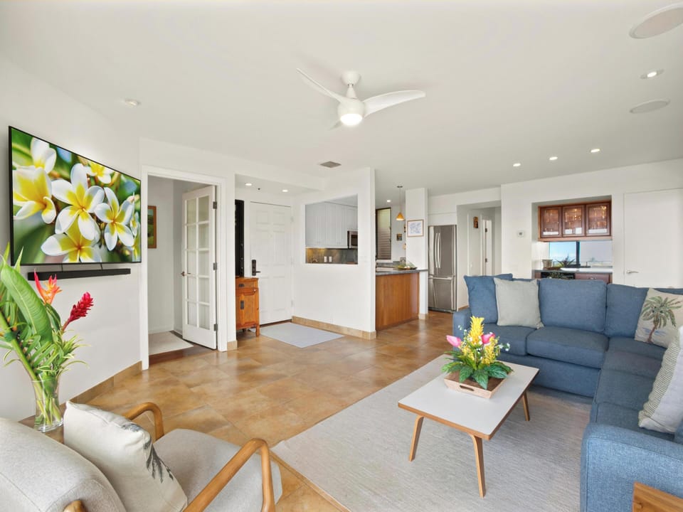 Unwind in your bright, open living space where modern comfort meets island style. Soft seating, warm wood accents, and tropical blooms create the perfect spot to relax after a day exploring paradise.
