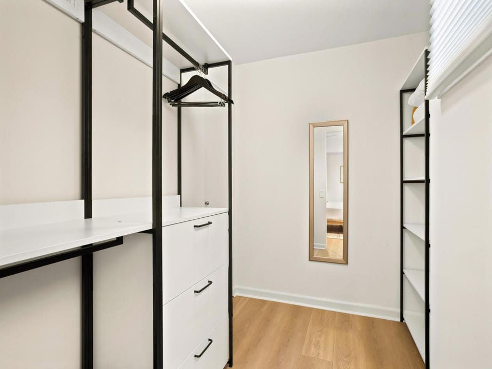 Store your belongings in this bright, well-organized walk-in closet. Sleek shelving, drawers, and hanging space give you plenty of room to settle in and feel right at home.
