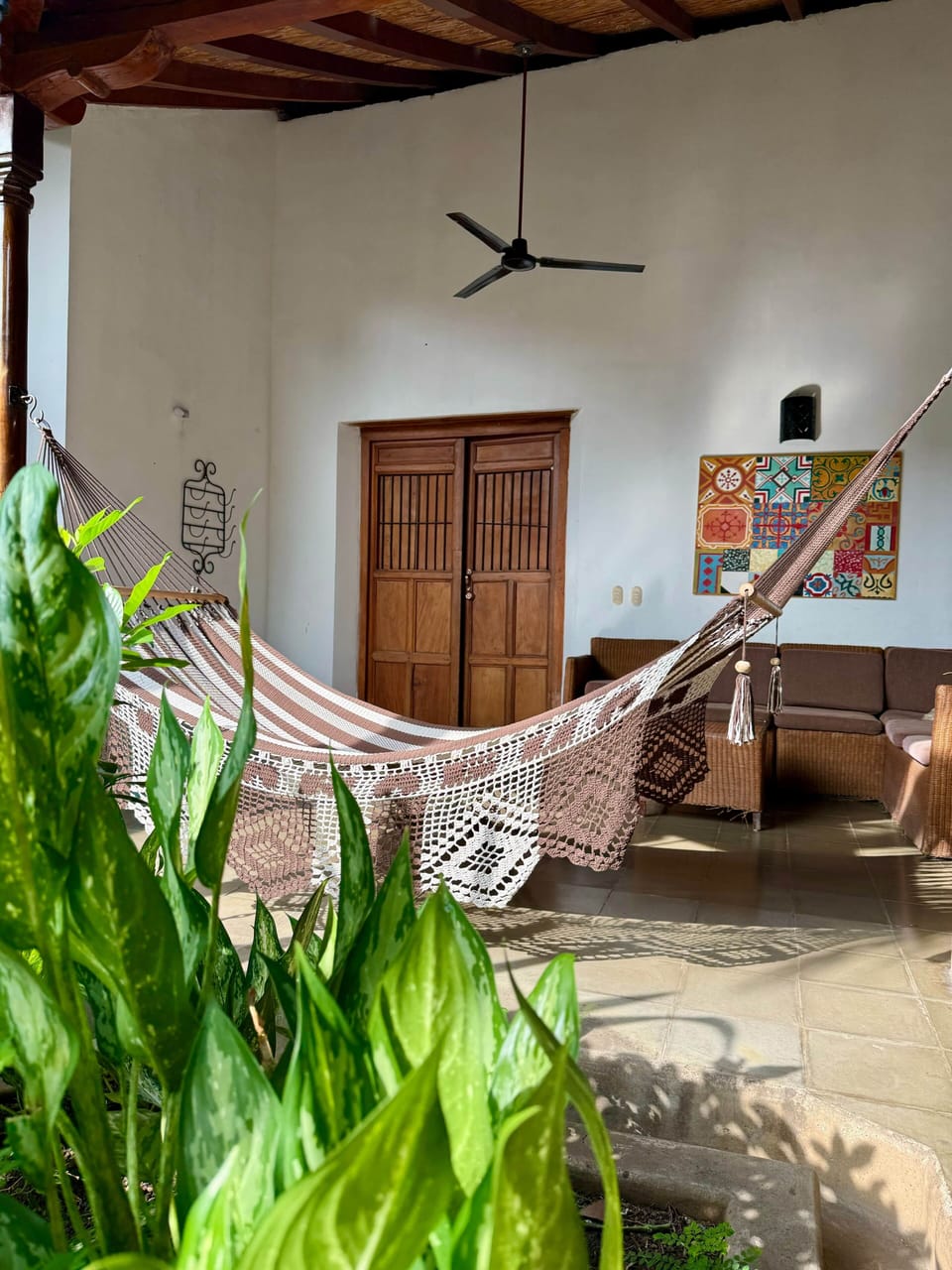 Shaded lounge terrace with a hammock and tile mural at our colonial villa in Granada, Nicaragua