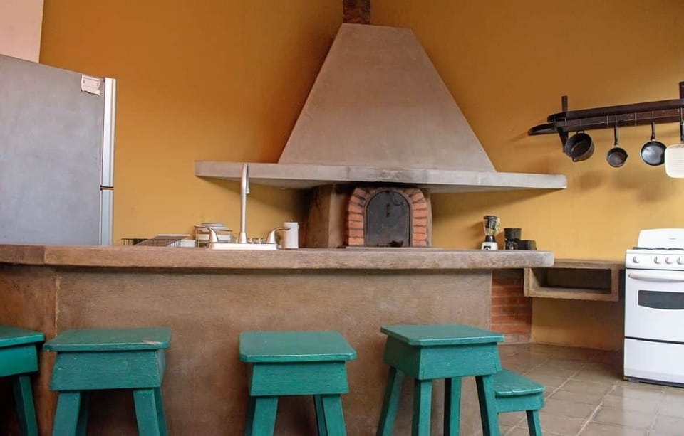Equipped kitchen with a traditional clay oven in this historic house rental in Granada