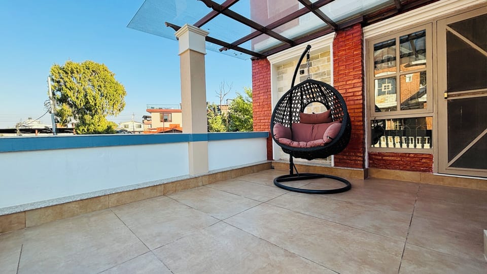 A charming balcony retreat with a cozy hanging egg chair, perfect for relaxing.
