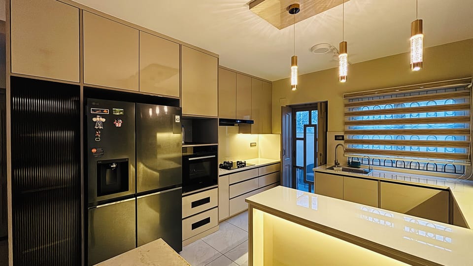 A bright, modern kitchen with sleek cabinetry, warm lighting, and elegant finish