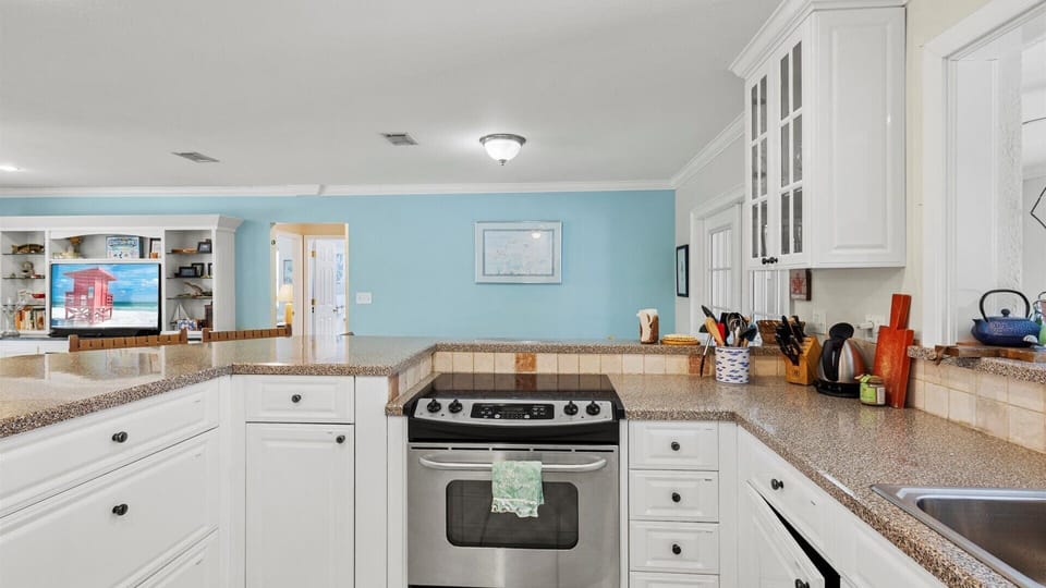 The kitchen shares the open floor plan with the living and dining areas and has a fridge, oven, stove, microwave, dishwasher, coffee maker, toaster, and expresso machine.