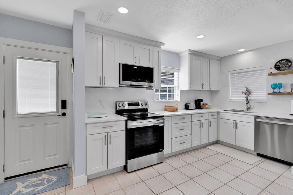Fully equipped kitchen with fridge, oven, stove, microwave, toaster, coffee maker, basic cooking utensils, dishware, and more!