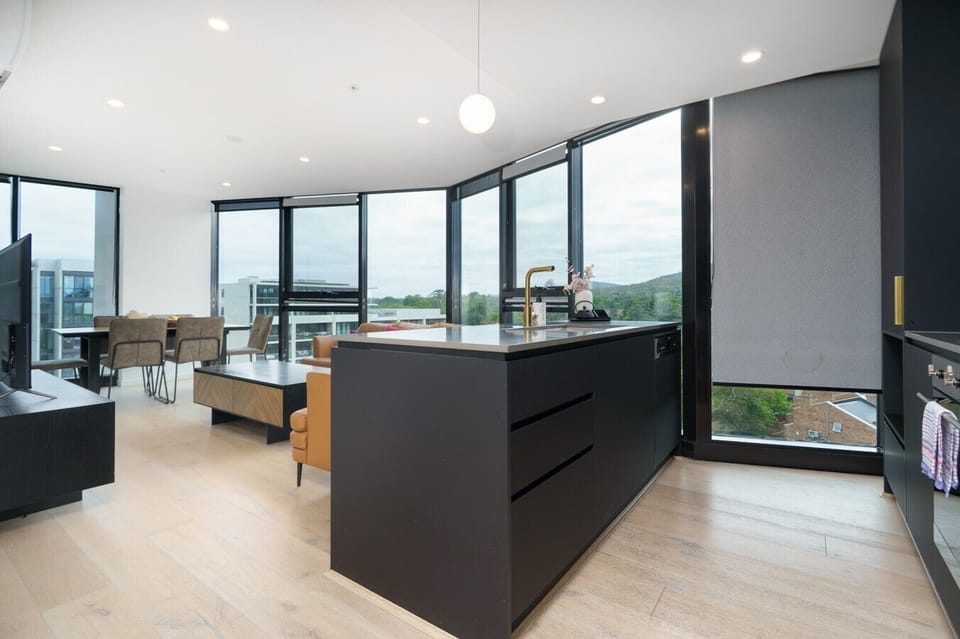 A sleek, modern kitchen fully equipped for easy home cooking, with quality appliances and plenty of bench space.