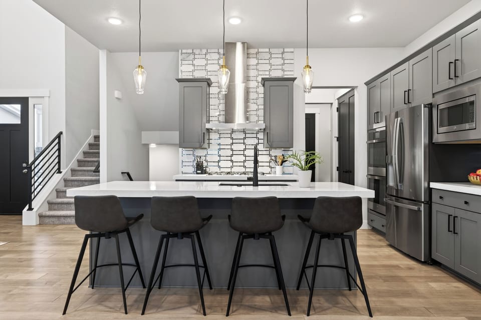 Sleek, chef-style kitchen with a spacious waterfall island, premium stainless appliances, and seating for casual meals or après-ski gatherings.