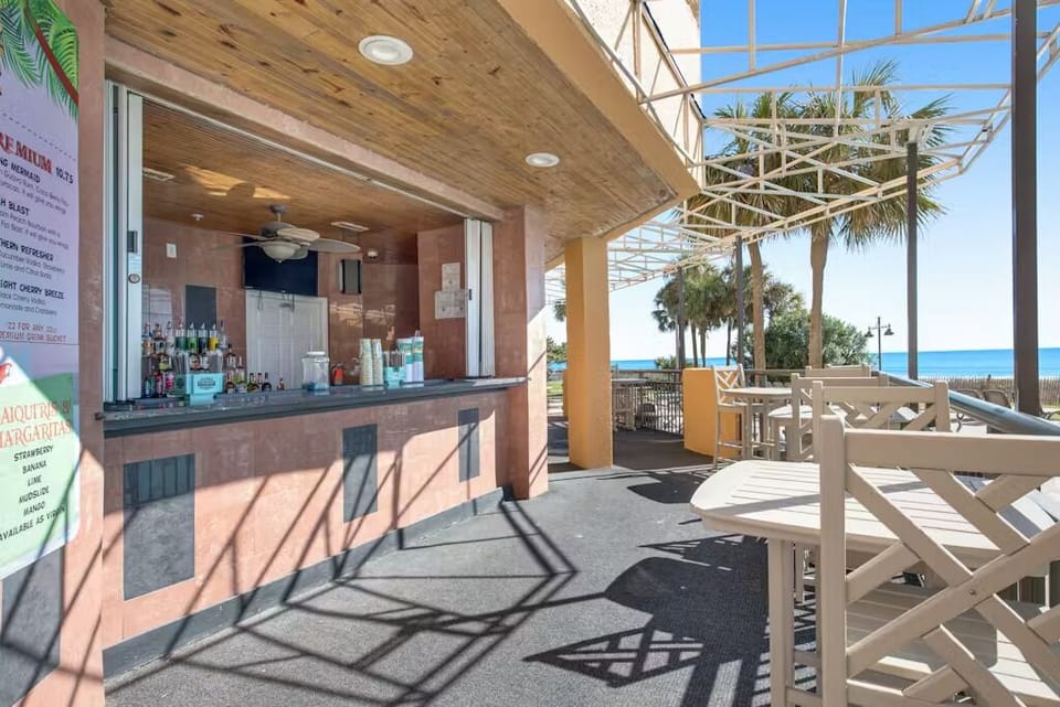 Oceanfront poolside bar with outdoor seating and sea breeze