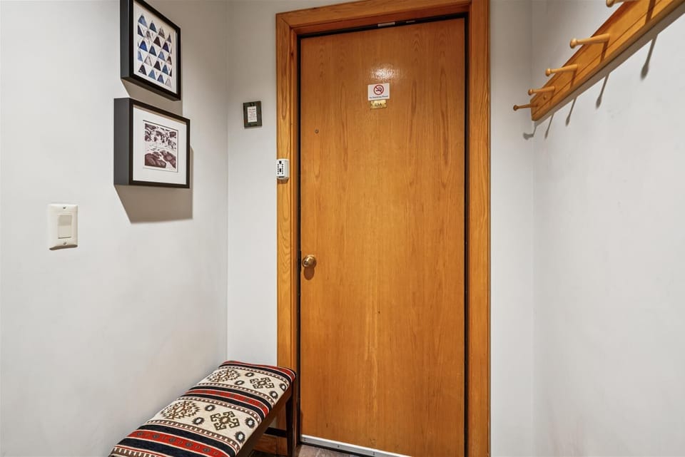 Shared entrance.  Keypad entry with bench and wall hooks for coats, boots, and day bags — a simple, easy place to come and go.