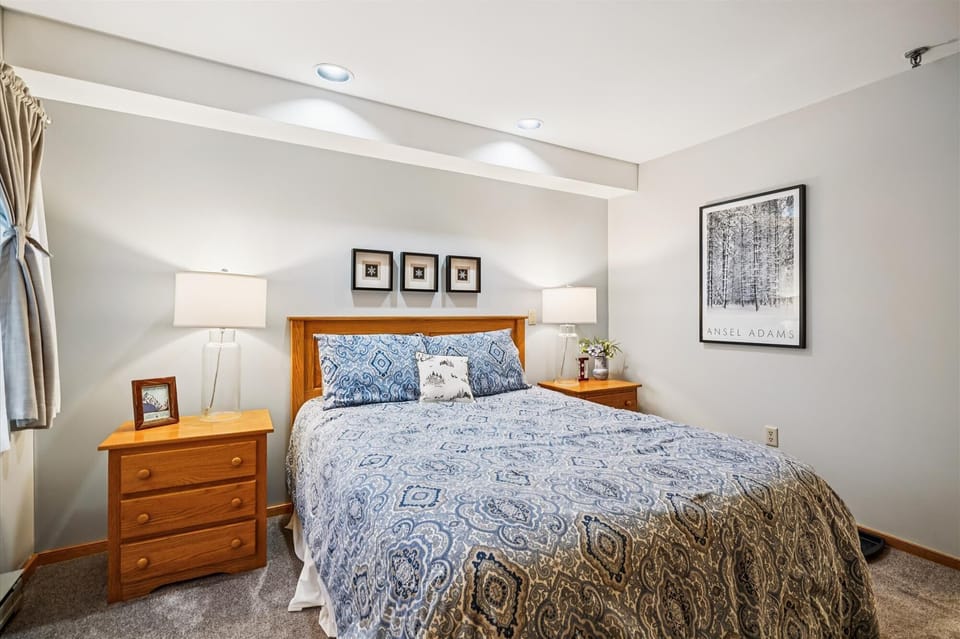 A thoughtfully designed queen room featuring a full private bath, warm lighting, and a quiet, restful setting.