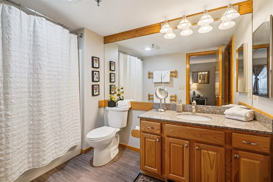 Bright bathroom with tub-shower combo, large vanity, mirror, and fresh towels — all right inside your room for easy mornings and quick clean-ups.