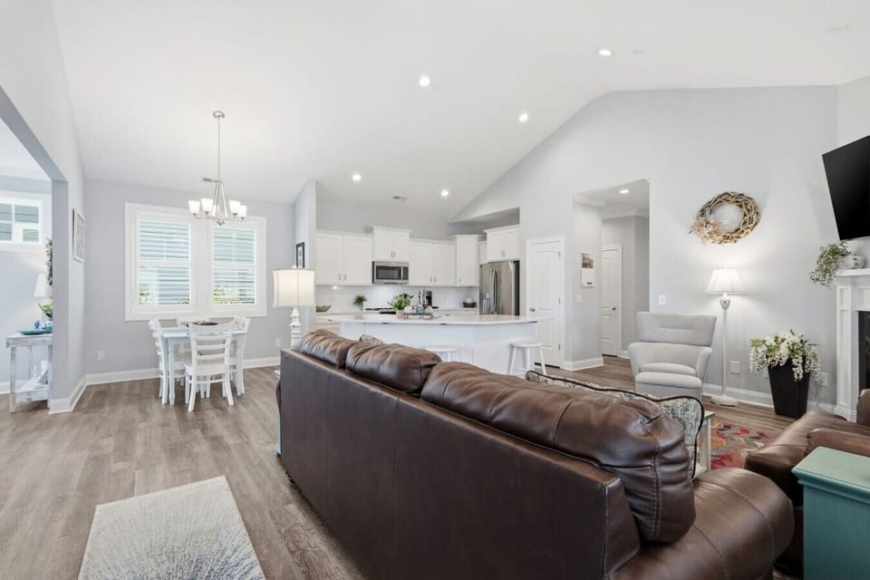 This open-concept layout seamlessly connects the living room, dining area, and fully equipped kitchen