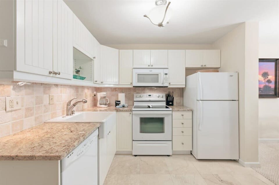 Fully equipped kitchen with modern appliances, ample counter space, and a dining breakfast bar.