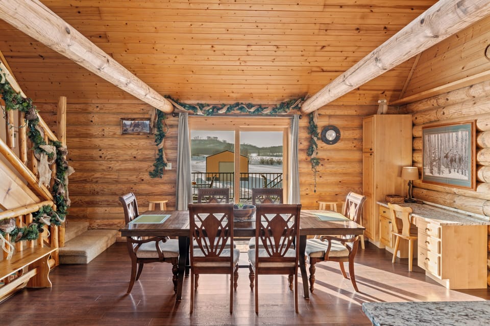 Warm log-cabin dining area with seating for six, vaulted ceilings