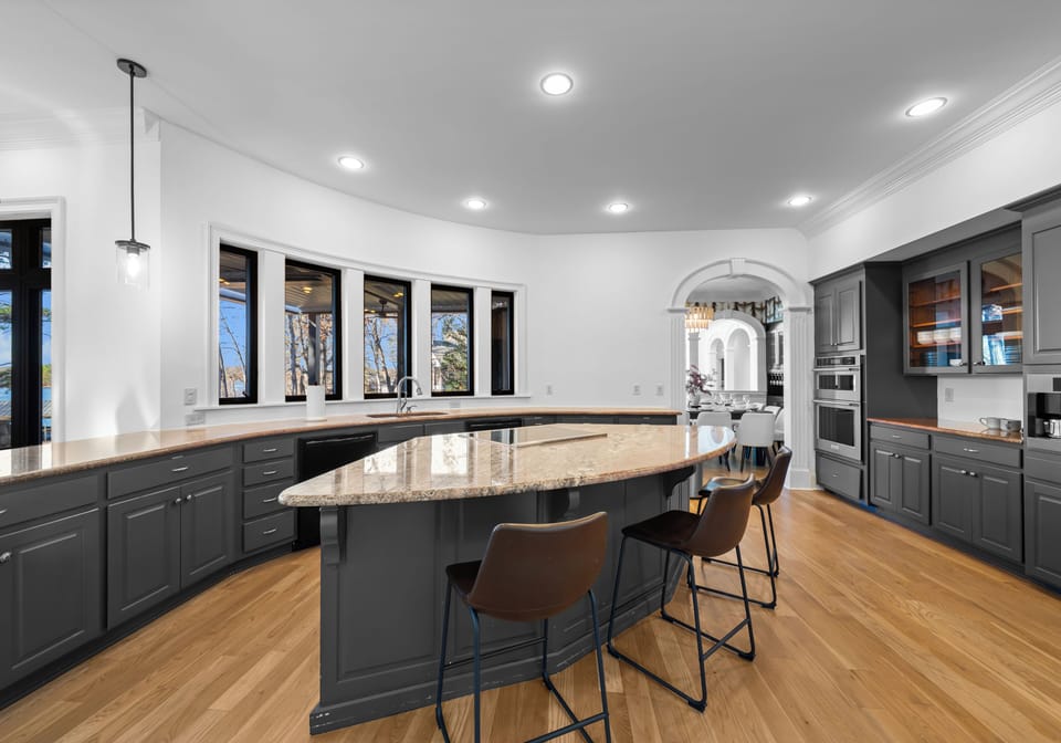 Gourmet kitchen featuring a curved island and dark cabinetry.