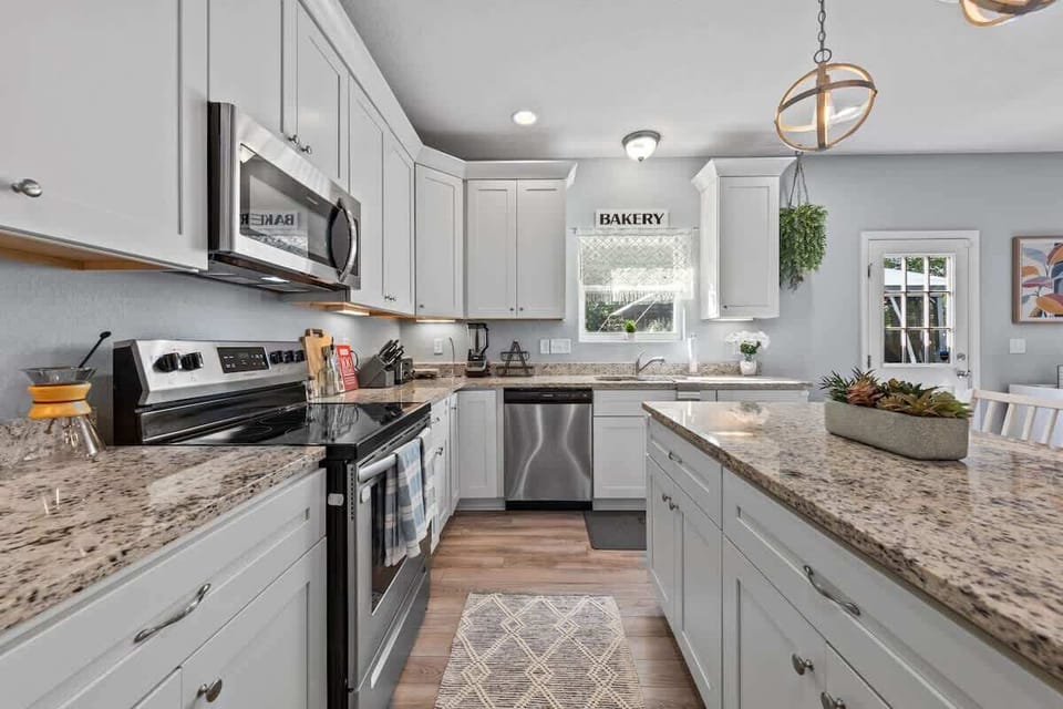 Sleek kitchen w/ granite counters, stainless appliances & ample prep space
