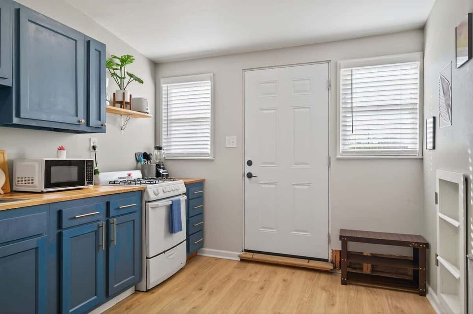 This kitchen angle showcases ample cabinets, counter space, and a bright entryway. The layout keeps everything easily accessible. 